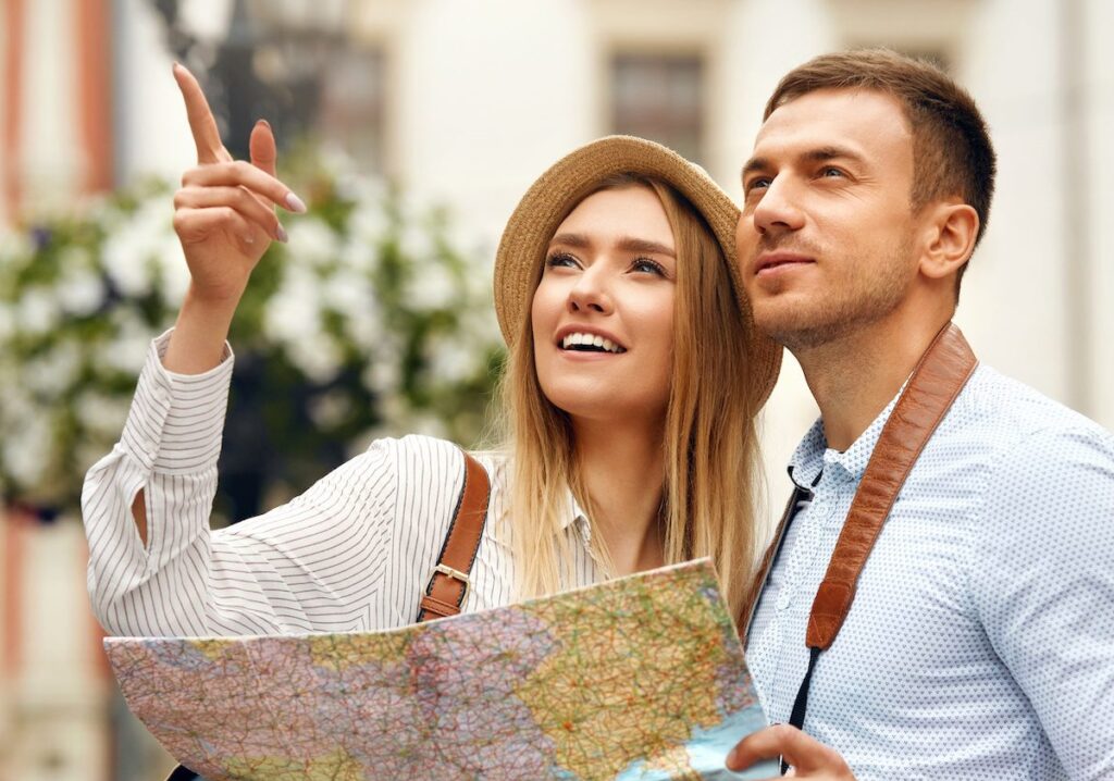 Pareja en viaje de novios consulta un mapa con el itinerario de su viaje antes de continuar con las actividades planeadas