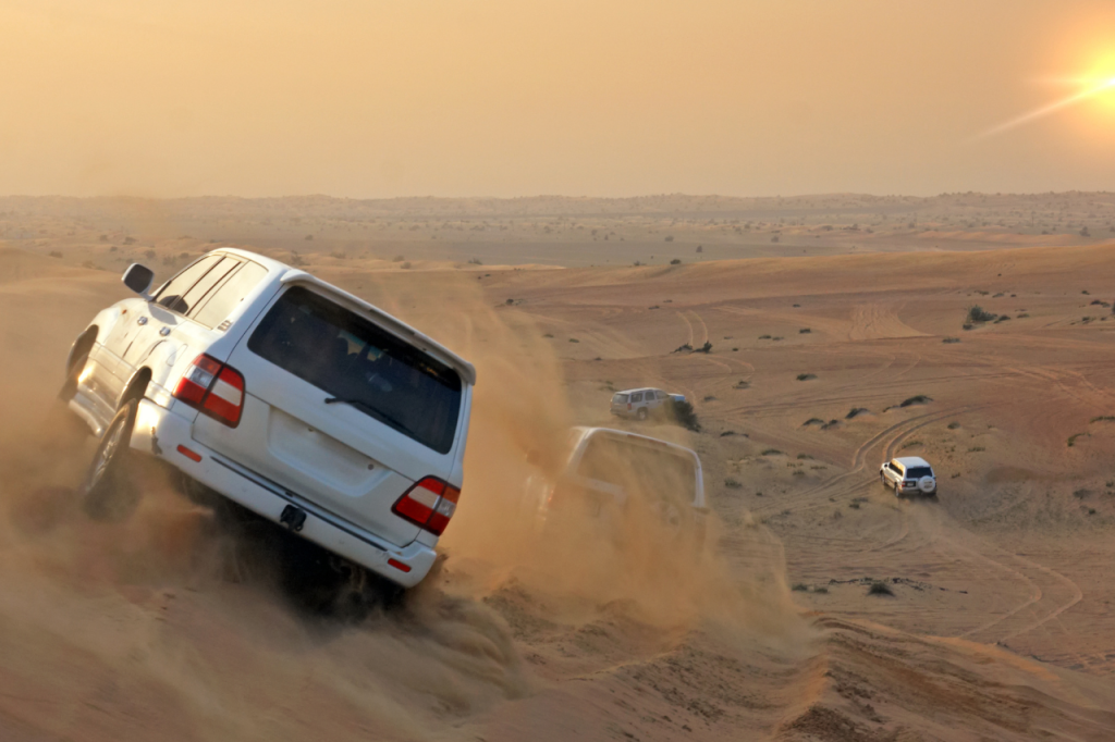 Vehículo todo terreno en primer plano durante un safari en el desierto de Dubai al atardecer
