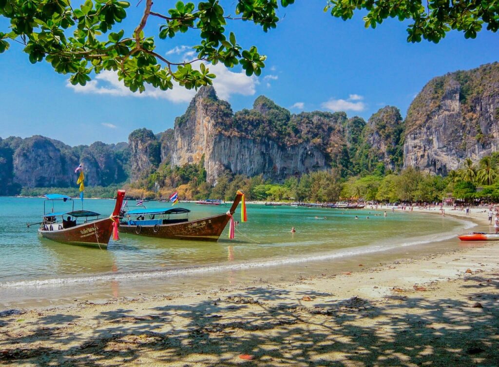 Barcas esperando en la orilla a los turistas de viajes organizados a Tailandia que visitan la playa para sus excursiones