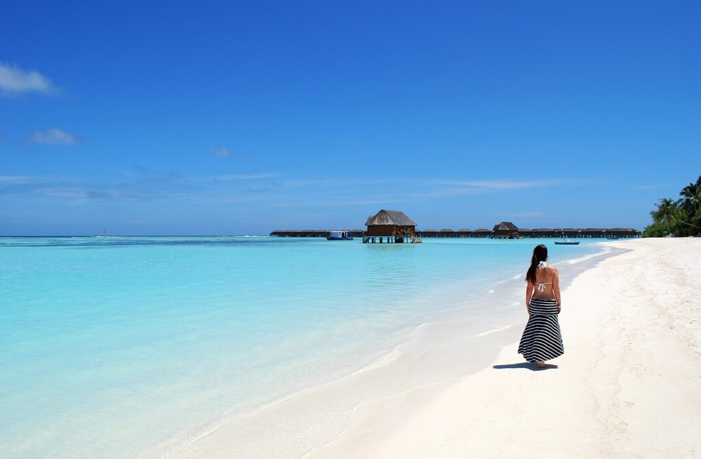 Mujer en playa paradisiaca de arena blanca en Maldivas durante su viaje de novios