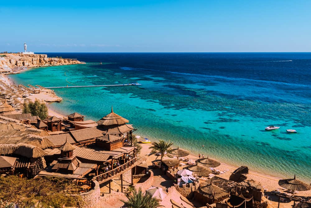 Vista aérea de una playa Sharm El Sheikh con el azul cristalino del mar rojo y en la parte inferior las instalaciones de un hotel de lujo en riviera egipcia