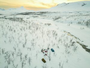a group of people walking across a snow covered field