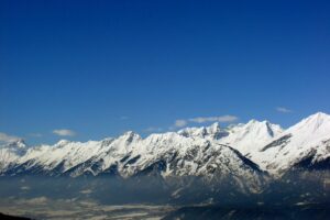 Panorámica de montañas alpinas cubiertas de nieve bajo un cielo despejado