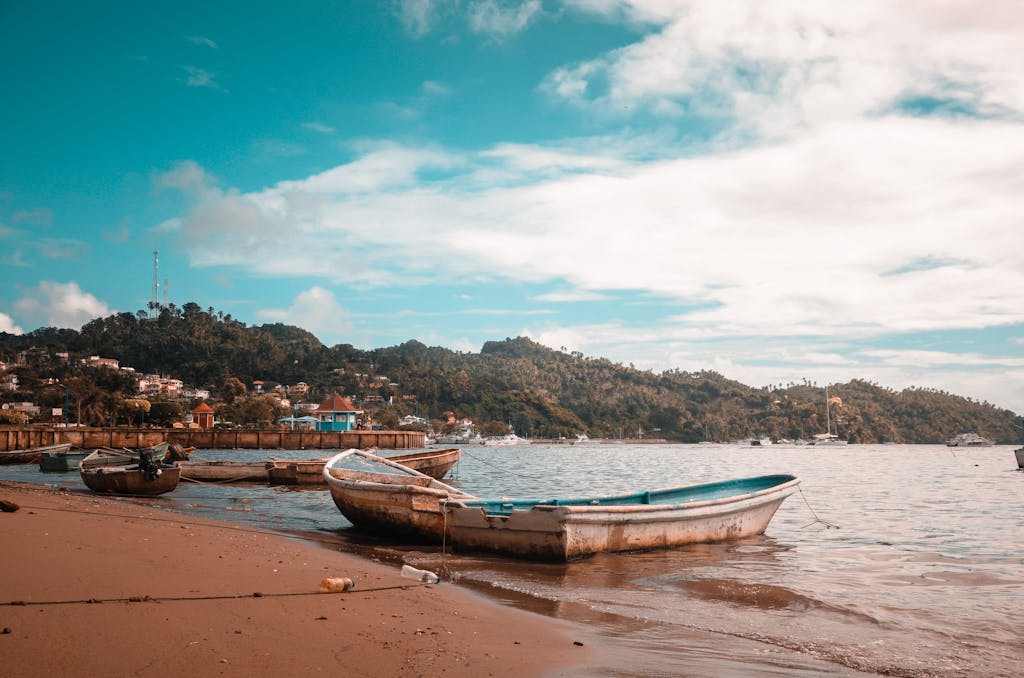 Serene beach with boats in Samaná, Dominican Republic under a vibrant sky.