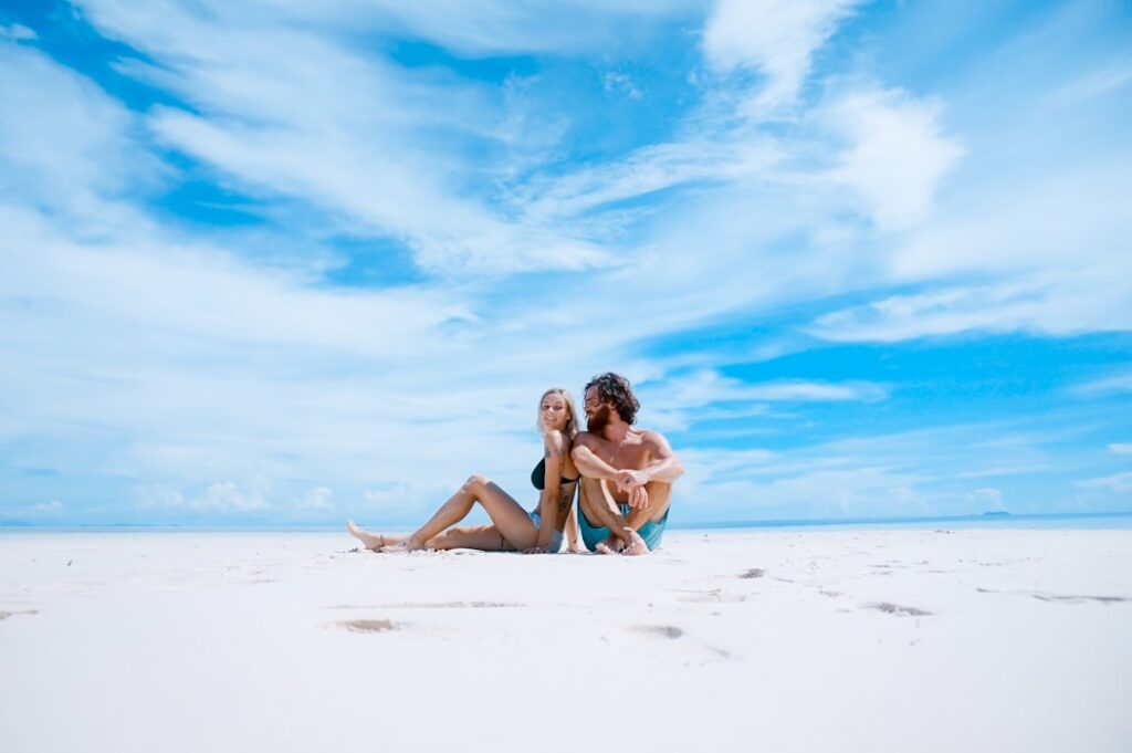 Pareja en la playa mirando a cámara durante su luna de miel
