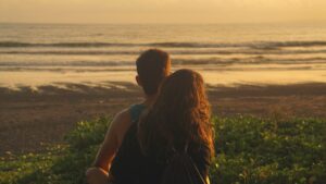 Pareja en la playa durante su luna de miel al atardecer