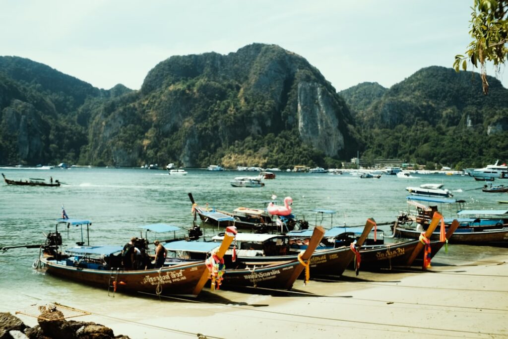 Playa de Krabi con barcos tradicionales y formaciones de piedra caliza en Tailandia