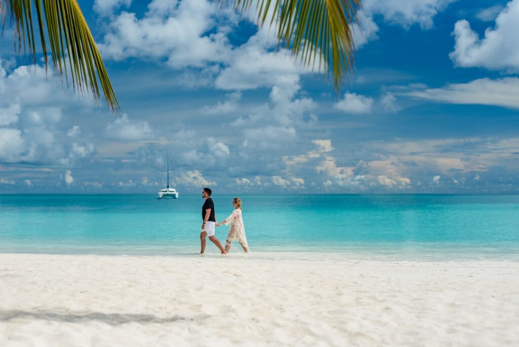 Pareja caminando por una playa durante su luna de miel
