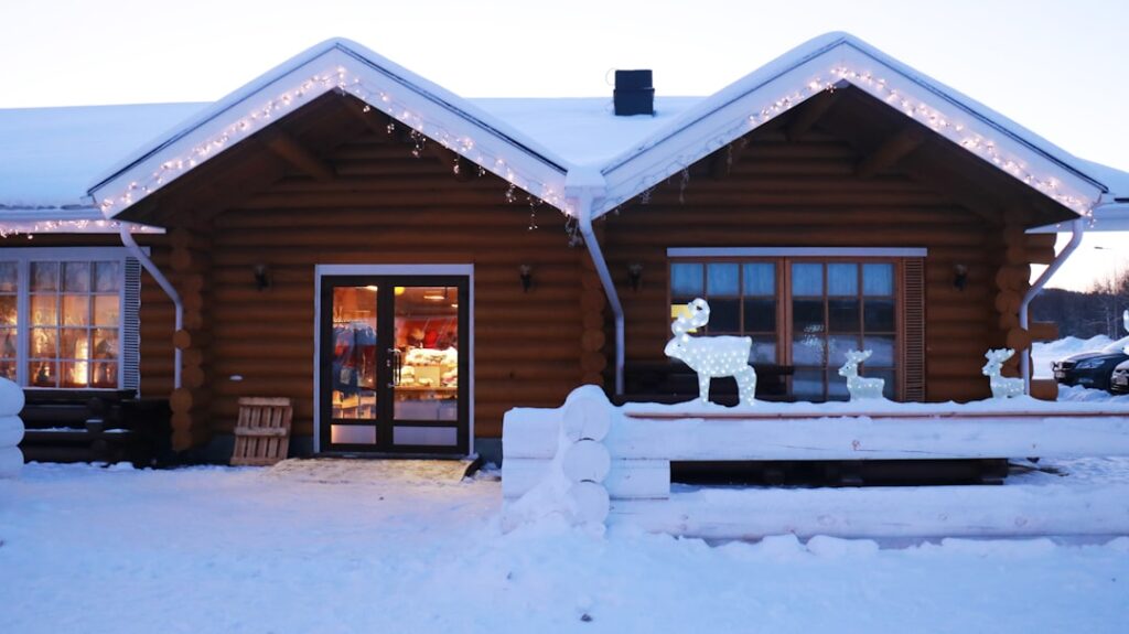 Cabaña iluminada entre nieve en Laponia durante la Navidad
