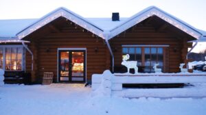 Cabaña iluminada entre nieve en Laponia durante la Navidad