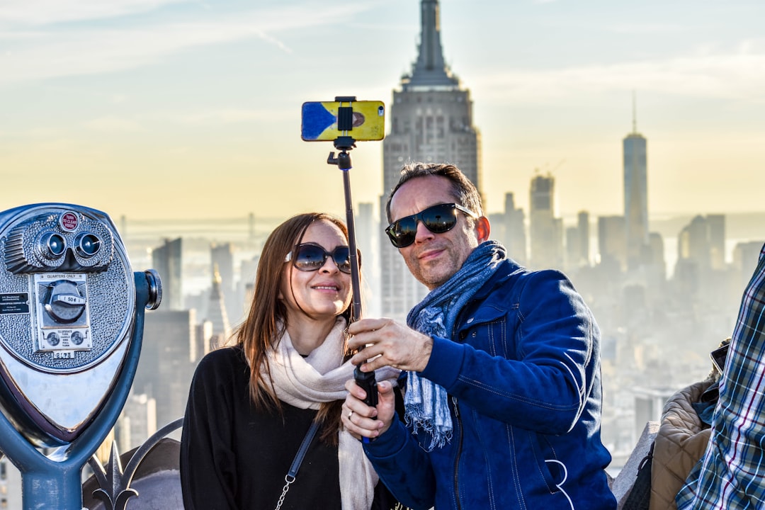 Pareja durante su viaje de novios en Nueva York con el Empire State al fondo