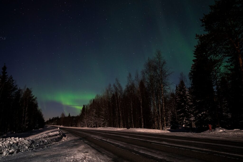 Cabaña nevada bajo una aurora boreal en Laponia finlandesa
