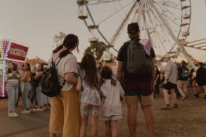 Familia contemplando una noria en un parque de atracciones
